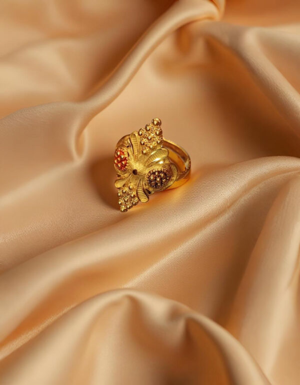 "Divy Gold 1 Gram Gold-Plated Ornate Floral Shield Ring displayed on soft beige satin fabric – ethnic elegance for every occasion."