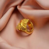 "Close-up of Divy Gold 1 Gram Gold-Plated Ornate Floral Shield Ring resting on blush satin, showcasing its intricate floral design."