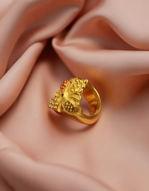 "Close-up of Divy Gold 1 Gram Gold-Plated Ornate Floral Shield Ring resting on blush satin, showcasing its intricate floral design."