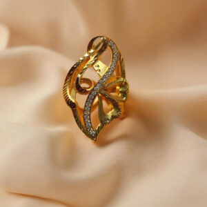 "DivyGold designer imitation ring with 1 gram gold polish and sparkling crystals on peach fabric background"